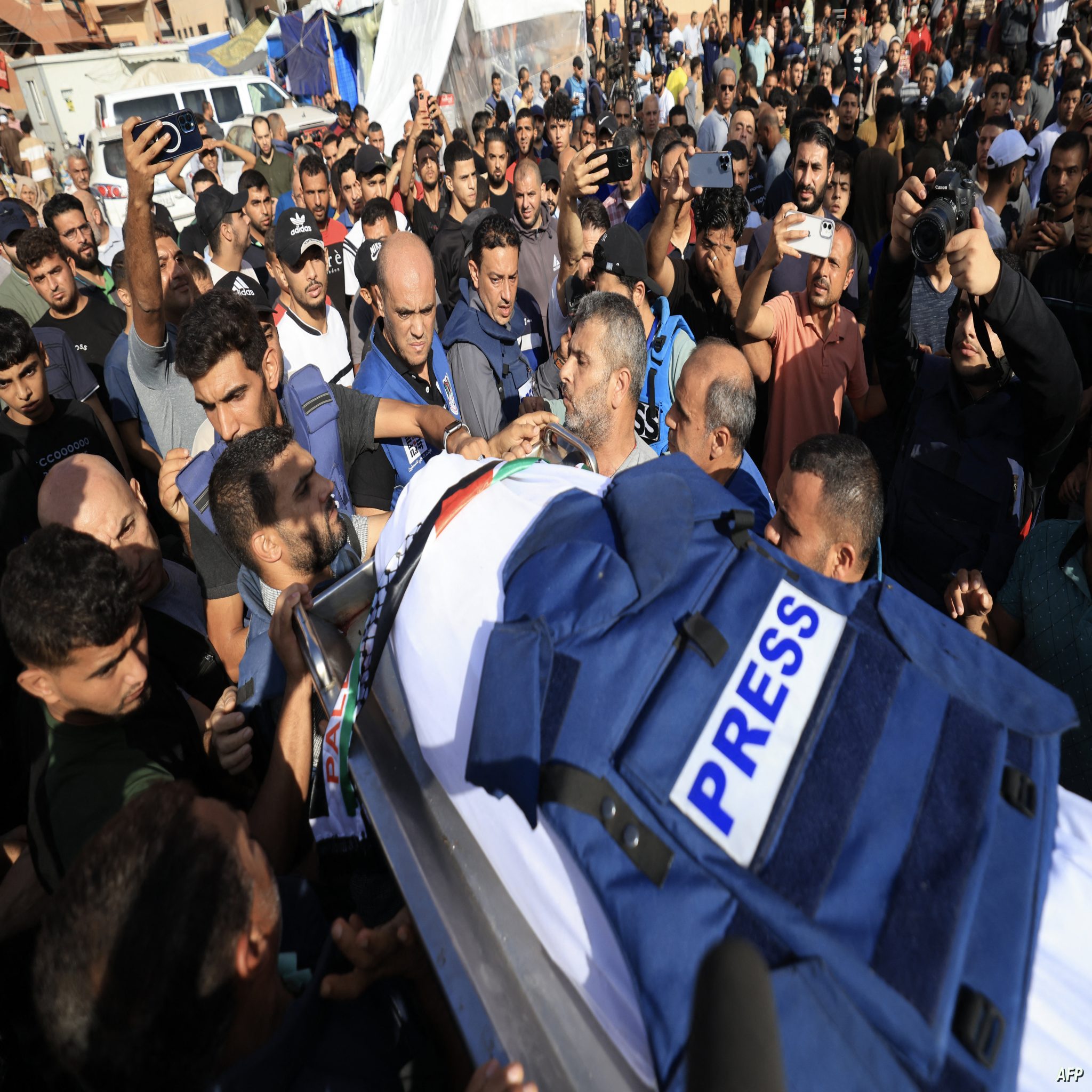 Journalists, relatives and friends pray over the body of Palestine TV journalist Mohamed Abu Hatab and eleven family members the day after they were killed when their home was hit in the Israeli bombardment of Khan Yunis, in the southern Gaza Strip on November 3, 2023, amid the ongoing battles between Israel and the Palestinian group Hamas. Thousands of civilians, both Palestinians and Israelis, have died since October 7, 2023, after Palestinian Hamas militants based in the Gaza Strip entered southern Israel in an unprecedented attack triggering a war declared by Israel on Hamas with retaliatory bombings on Gaza. (Photo by Mahmud HAMS / AFP)